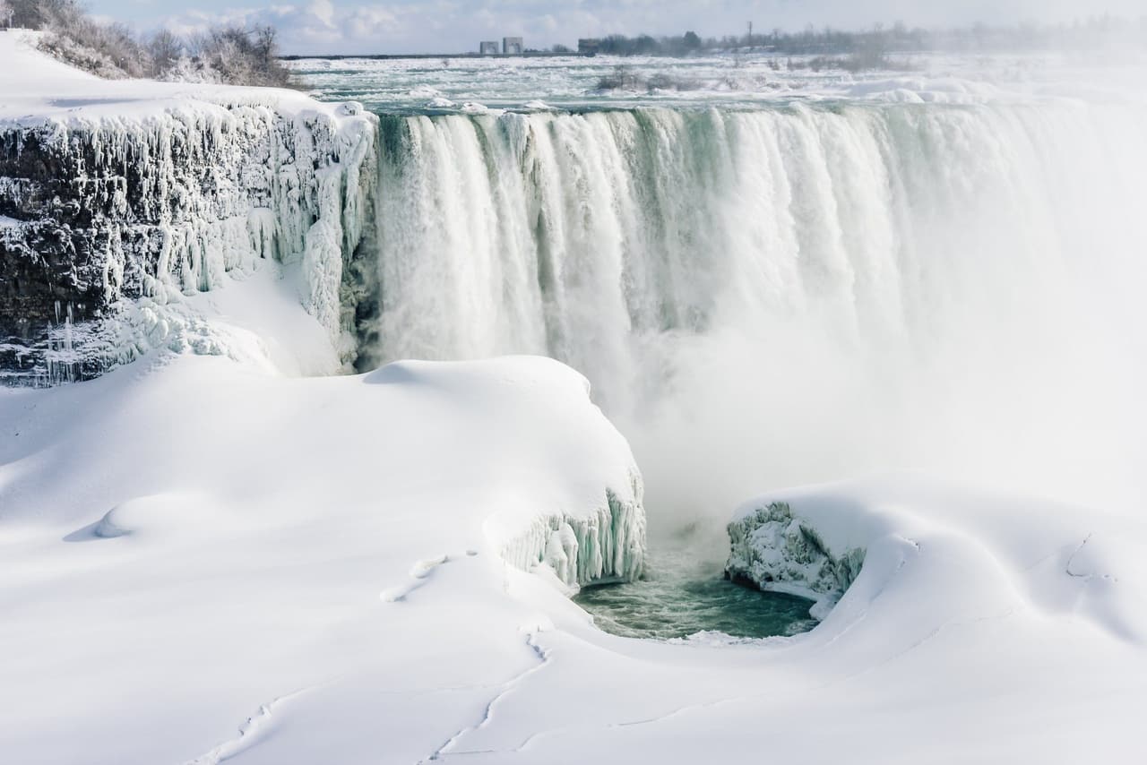 Guests at the frozen falls on a winter tour